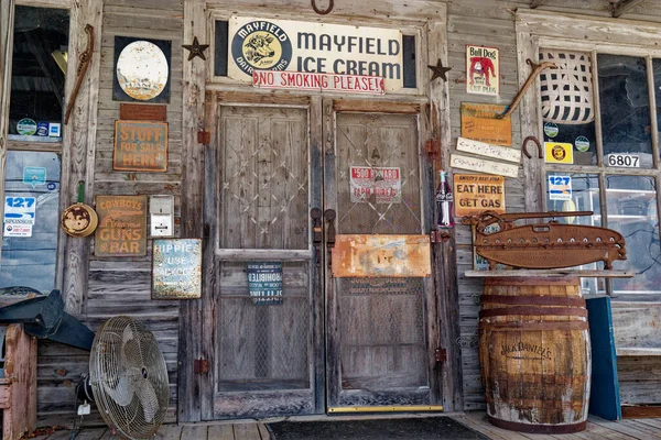 stock image Clarkrange, Tennessee USA - March 25, 2023  An old country general store front entryway surrounded by vintage items on the porch and rusty antique signs on the building and doors closeup view