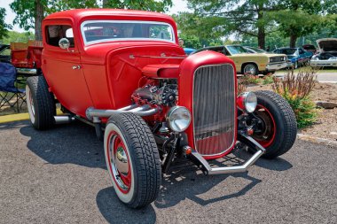 Parlak kırmızı restorasyon özelleştirilmiş beyaz duvar lastikleri ve güneşli bir yaz gününün erken saatlerinde bir araba fuarında park etmiş bir motor.