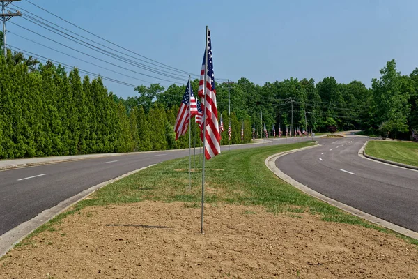 夏の晴れた日の7月4日のお祝いのシンボルとして 道路の真ん中に並んでいるいくつかのフルサイズのアメリカ国旗 — ストック写真