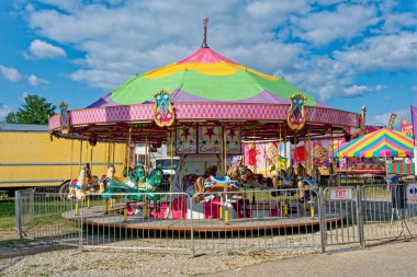 Parlak ve renkli neşeli, yaz mevsiminin güneşli bir gününde panayırda hazır ve nazır yemek satıcılarıyla at karnavallarıyla dolaşır.