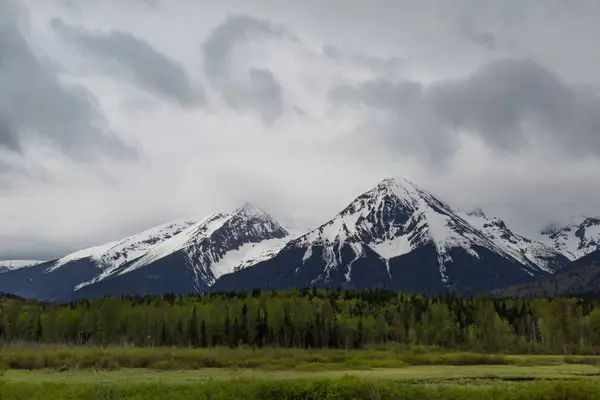 Blick Auf Schneebedeckte Berggipfel Mit Wäldern Und Feuchtgebieten Entlang Der Stockfoto