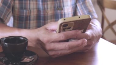 Adamın eli cep telefonuyla oynuyor..