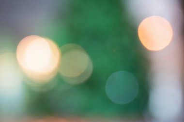Bulanık bokeh yeşil ağacı, doğa ormanının odak arka planında ampullerle süslenmiş..