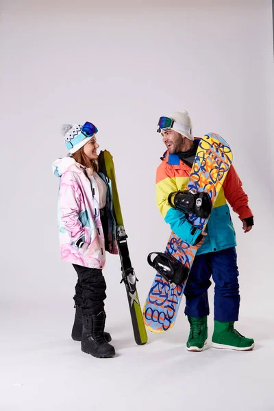 笑顔の女の子と男の子がスノーボードや白い背景のスキーと話しています — ストック写真