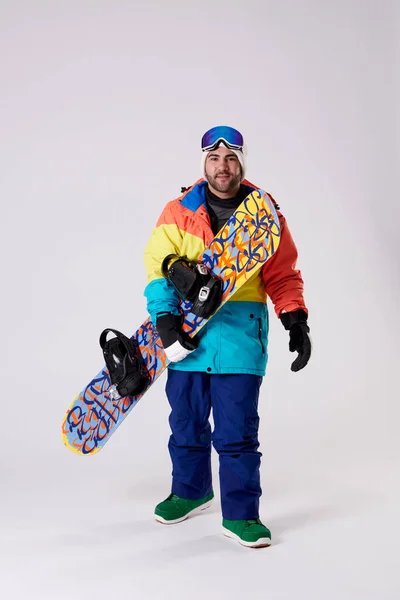 Mężczyzna Zimowych Ubraniach Trzymając Snowboard Patrząc Aparat Białym Tle — Zdjęcie stockowe