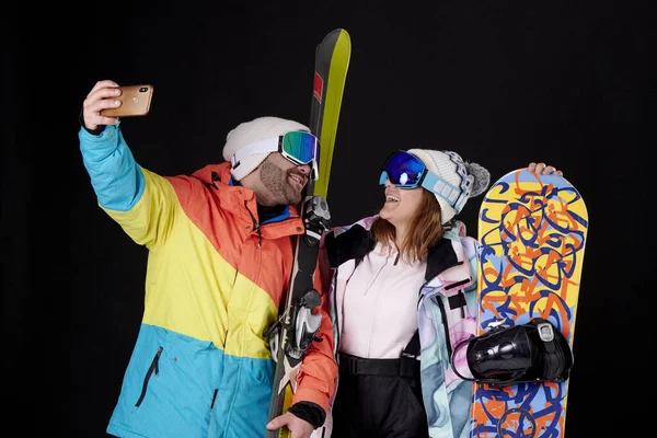 笑顔の男の子と女の子が黒を背景にスノーボードやスキーをした雪のゴーグルで自撮り — ストック写真