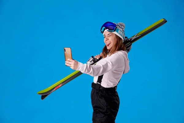 Девушка Лыжами Снегом Смотрит Свой Мобильный Телефон Делая Селфи Языком — стоковое фото