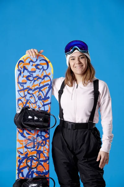 Lächelnde Frau Schneebekleidung Die Die Kamera Blickt Und Ein Snowboard — Stockfoto