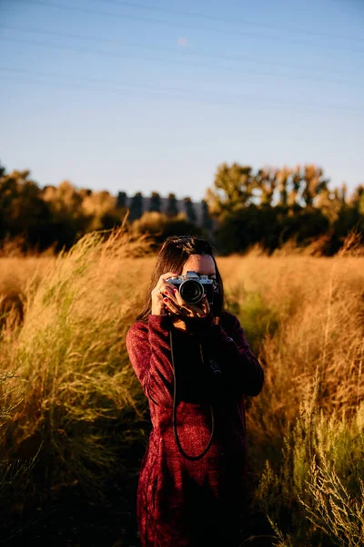 빈티지 카메라를 초원을 거닐며 석양을 즐기면서 사진을 — 스톡 사진
