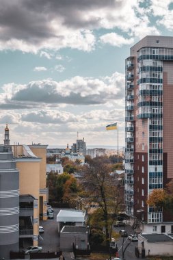 Kharkiv şehir merkezi. Sonbaharda konut binaları, katedral kubbeleri ve gökyüzü manzaralı ulusal bayrak direğine bakın. Ukrayna