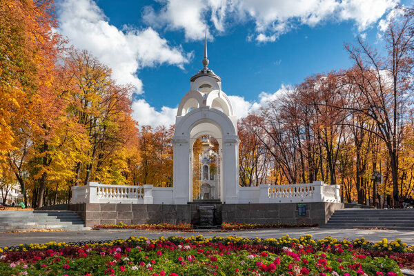 Ориентир Зеркального потока с цветами, фонтаном и мироносицей в красочном осеннем парке Харькова, Украина