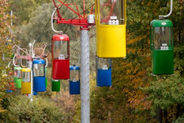 Kharkiv şehir eğlence parkında sonbahar ağaçlı renkli kablo taşıma kabinleri