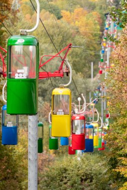 Kharkiv şehir eğlence parkında sonbahar ağaçlarıyla dolu renkli kablolu füniküler kulübeler