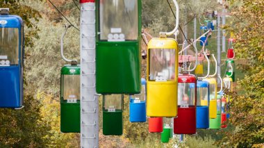 Kharkiv kenti dinlenme parkında sonbahar ağaçlı renkli kablo taşıma kabinleri.