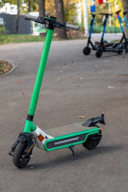 Elektrikli scooter 'lar sonbahar kenti dinlenme alanına park ediyorlar. Genel e-scooter, yeşil popüler ulaşım