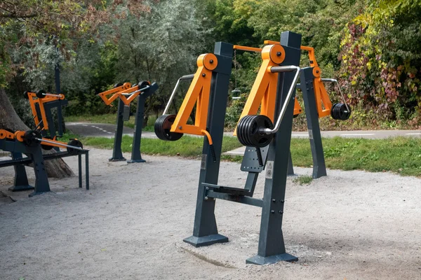 Open air sports ground with weight training equipment in city park. Municipal workout space in green recreation area