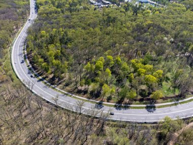 Çevresi ormanla çevrili, yeşil yapraklarla çevrili olan otoyol kavşağına bak. Kharkiv şehir sokakları