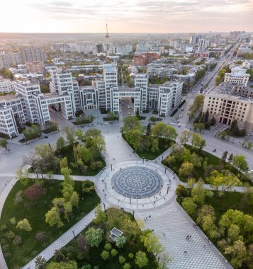 Sunset city aerial panoramic view on Derzhprom building and Freedom Square central fountain circle with epic golden cloudscape in Kharkiv, Ukraine clipart