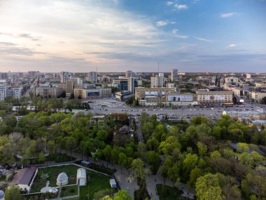 Svobody Meydanı 'ndaki hava manzarası ve parktan günbatımı gökyüzü olan tarihi binalar. Kharkiv, Ukrayna baharda
