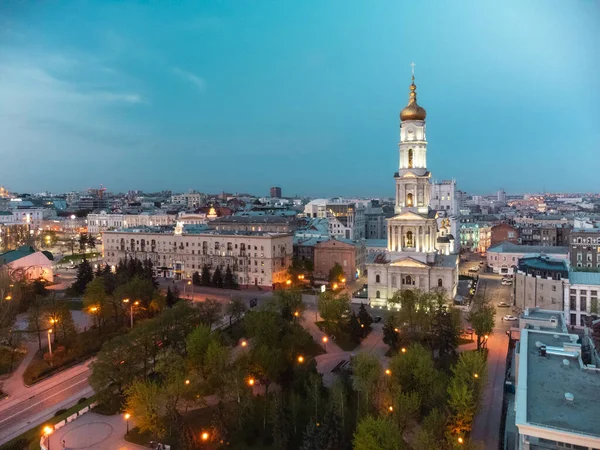ウクライナのダウンタウンのハリコフ市の夜のライトで青い夕日の空に黄金のドームと鐘楼とドーミション大聖堂の空中ビュー — ストック写真
