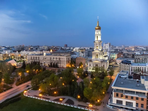 ウクライナのダウンタウンのハリコフ市の夜の光の中で青い空に金色のドームと鐘楼と空中回廊の大聖堂 — ストック写真