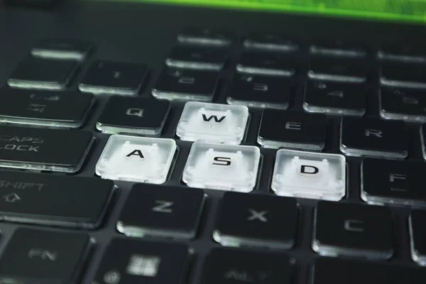 Kunci Permainan Disorot Dengan Latar Belakang Kabur Keyboard Notebook Gelap — Stok Foto