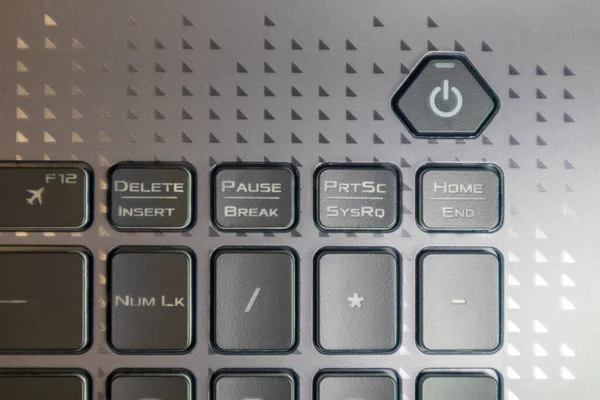 Turn on and off power key button. Gaming grey notebook keyboard close-up. Tech, IT, electronics, computer science background