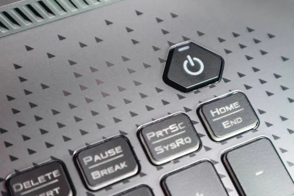 Turn on power key button. Gaming grey notebook keyboard close-up. Tech, IT, electronics, computer science background