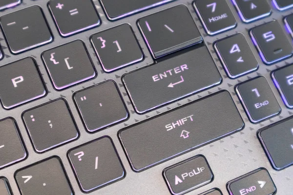 进入并移动带有紫色照明的键 游戏强大的灰色笔记本电脑键盘特写 计算机科学背景 — 图库照片