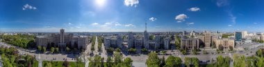 Özgürlük Meydanı 'ndaki Derzhprom ve Karazin Ulusal Üniversitesi binaları üzerinde bahar yeşili ve Ukrayna' nın Harkiv kentinde mavi güneşli gökyüzü ile geniş panoramik manzara