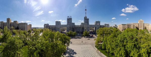 Aerial view on Derzhprom and Karazin National University buildings on green Freedom Square with blue sunny sky in Kharkiv, Ukraine