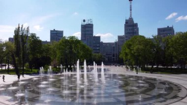 Kharkiv, Ukrayna - 13 Mayıs 2021: Kharkiv şehir merkezindeki Freedom (Svobody) Meydanı 'nda ilkbaharda kaynak ve yeşil parkla Derzhprom binasının hava durağan görüntüleri