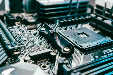 Modern güçlü bilgisayarın ana kartında AM4 işlemci soketi var. Bilgisayar donanımı yonga seti bileşenleri mavi ışıkta yakın plan. Teknoloji endüstrisinin elektronik geçmişi