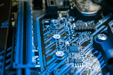 Modern güçlü masaüstü bilgisayarında mavi ışıkta prizleri ve mikroçipleri olan ana kart. Bilgisayar donanımı yonga seti bileşenleri. Teknoloji endüstrisinin elektronik geçmişi