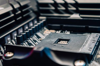Güçlü masaüstü bilgisayarının ana kartında AM4 işlemci soketi. Bilgisayar donanımı yonga seti bileşenleri mavi ışıkta yakın plan. Teknoloji endüstrisinin elektronik geçmişi