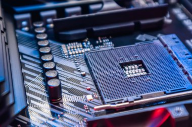 Modern güçlü bilgisayarın ana kartında AM4 işlemci soketi var. Bilgisayar donanımı yongası mavi ışıkta yakın plan. Teknoloji endüstrisinin elektronik geçmişi