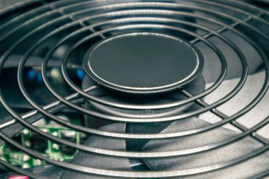 Masaüstü bilgisayar işlemcisi soğutma radyatörünü kapatıyor. Metal ağlı siyah fan, PC donanım detayları. Güçlü kişisel bilgisayardan bileşenler