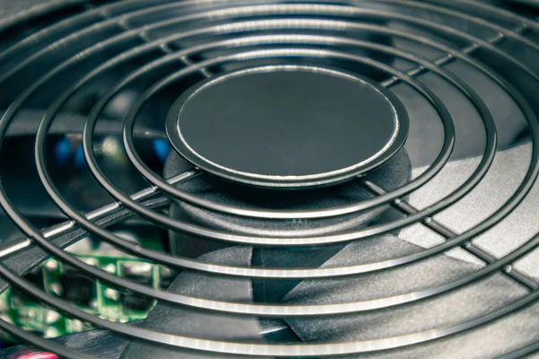 Masaüstü bilgisayar işlemcisi soğutma radyatörünü kapatıyor. Metal ağlı siyah fan, PC donanım detayları. Güçlü kişisel bilgisayardan bileşenler