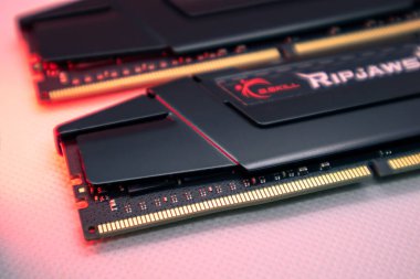 Kyiv, Ukrayna - 05 Ocak 2022: G.Skill Ripjaws V serisi DDR4 DRAM hafıza modülleri kırmızı ışıkta. Bilgisayar RAM çipi beyaza yakın çekim yapıyor. Montaj için masaüstü bilgisayar belleği parçaları