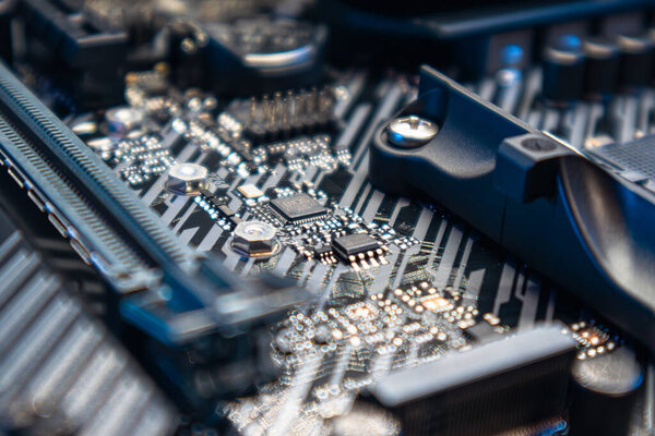 Киев, Украина - 05 января 2022 года: Современная материнская плата Asus Tuf Gaming с микрочипами и розетками. Компоненты чипсетов компьютера крупным планом синим светом. Техника и электроника