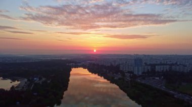 Havadan geriye doğru uçmak, gölde gün doğumu sakin ayna su yüzeyine yansıyan bulutlar. Sabah Kharkiv nehri şehir parkında, yerleşim bölgesi yakınlarında.