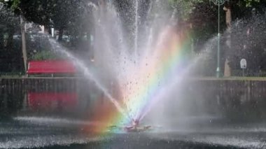 Dinlenme alanındaki bir gölün üzerinde parlak gökkuşağı olan parlak, ışıl ışıl bir çeşme. Central City Park 'taki turistik ilgi merkezi, Kharkiv Ukrayna