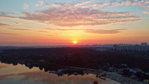 ビーチレクリエーションエリアと湖に日の出の太陽の光の映像を引き出します 住宅街近くの市立公園のハリコフ川による朝 — ストック動画