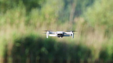 Kharkiv, Ukrayna - 02 Temmuz 2021: Dji Mini 2 İHA, yeşil yaz doğasında uçuyor. Quadcopter aygıtı bulanık arkaplan ile geziniyor