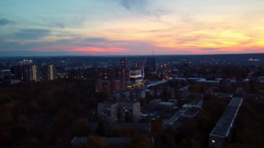Günbatımında hava sonbahar şehir parkı, sokakları aydınlatıyor. Akşamları konut binaları ve arabalar sürüyor
