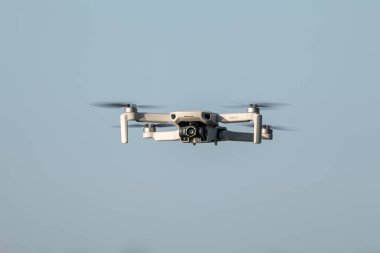 Kharkiv, Ukrayna - 02 Temmuz 2021: Dji Mini 2 İHA, güneşli bir günde uçuyor. Mavi açık gökyüzü arka planında süzülen yeni kuadrokopter cihazı. Kopyalama alanı ile ön görünüm