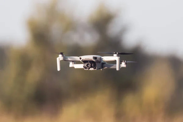 Kharkiv, Ukrayna - 02 Temmuz 2021: Dji Mini 2 insansız hava aracı, ılık, güneşli yeşil yaz mevsiminde uçuyor. Çeyrek helikopter aygıtı bulanık ağaçlar ve yeşillik arkaplanı üzerinde gezinir