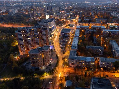 Gün batımında şehir sokağına aydınlatmayla hava bakışıyla. Kharkiv şehir merkezi yerleşim bölgesi binaları ve araçları akşam saatlerinde sürüyorlar