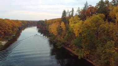 Nehirde ormanlık nehir kıyıları olan balıkçı teknesini takip eden sonbahar havası. Ukrayna 'daki Siverskyi Donets Nehri