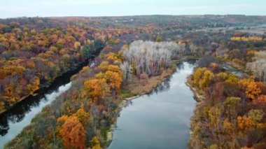Nehir kenarlarında renkli ağaçlar olan bir nehrin hava yayı uçuş görüntüleri. Siverskyi Donets nehrinde sonbahar Ukrayna 'da sakin ayna suyuyla